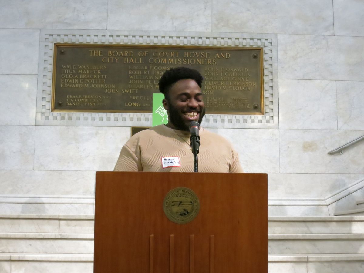 A young person speaking at a City Hall podium